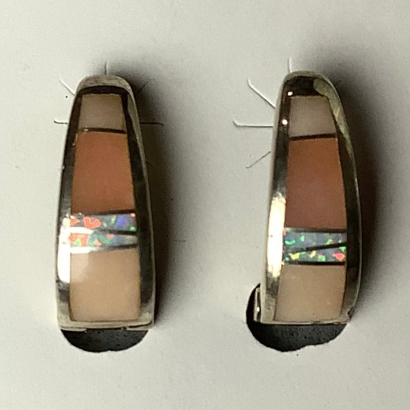 A pair of silver-colored earrings with insets of pink opal, displayed on a flat surface.