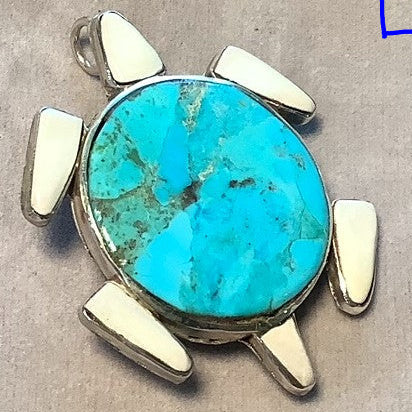Turquoise stone pendant with silver accents on a textured beige background