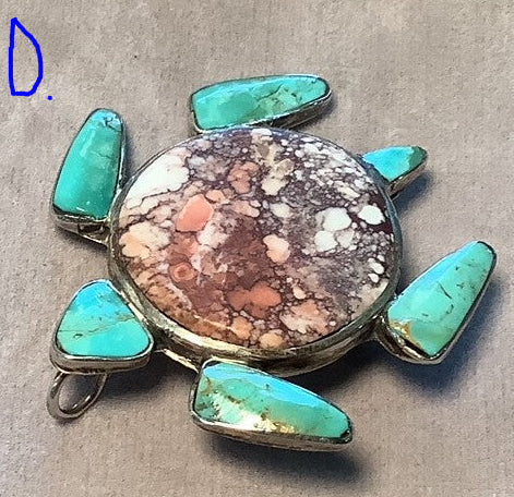 Turtle-shaped pendant with turquoise stones on a gray background